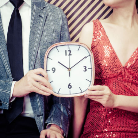 Man and woman holding clock