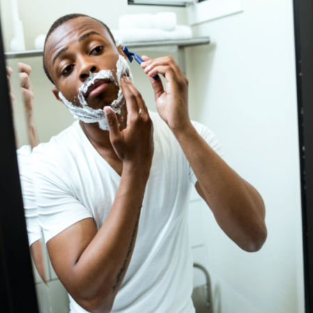 Man shaving in mirror