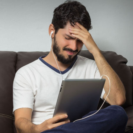 Man on tablet looking frustrated