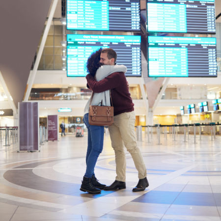 Couple in a long-distance relationship greet each other at the airport